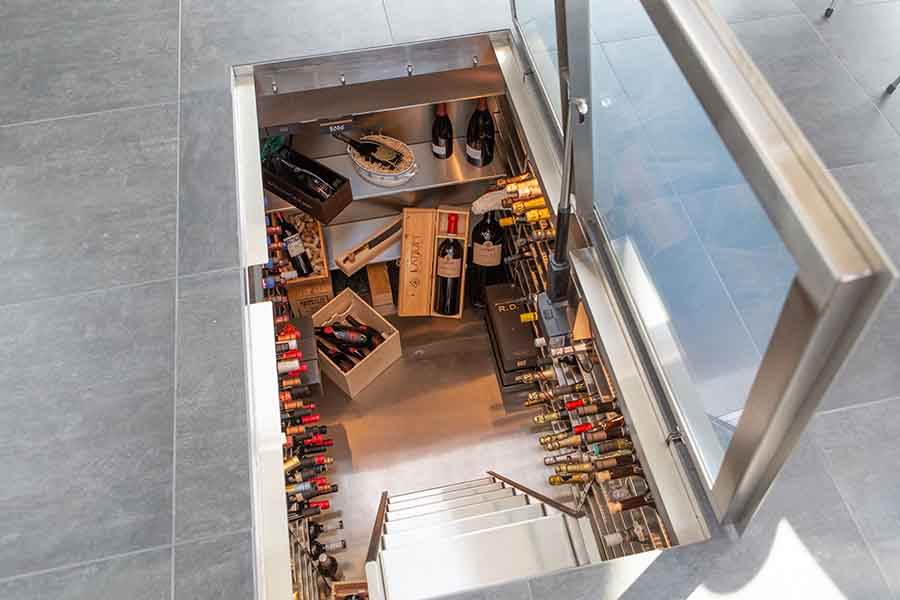 Wine cellar installed in basement with glass hatch