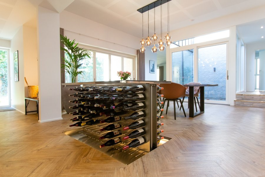 Elevation wine cellar integrated into the floor with lift system and wine bottles