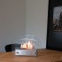 Circular tabletop fireplace wit glass panels on the sides