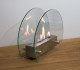Circular tabletop fireplace wit glass panels on the sides